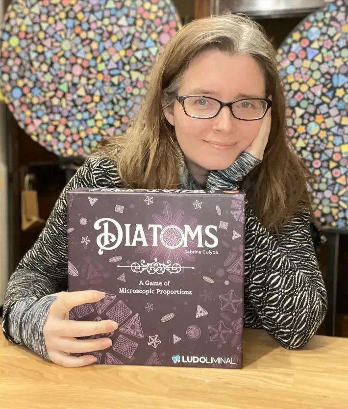 Sabrina with the box of her new game, Diatoms